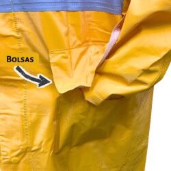 Primer plano de la parte lateral de un impermeable amarillo, señalando claramente uno de los bolsillos frontales, destacando la funcionalidad para guardar objetos